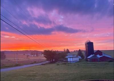 Paysage rural au coucher du soleil, avec grange et silo