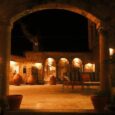 Cour intérieure en pierre éclairée de nuit sous des arcades