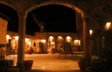 Cour intérieure en pierre éclairée de nuit sous des arcades